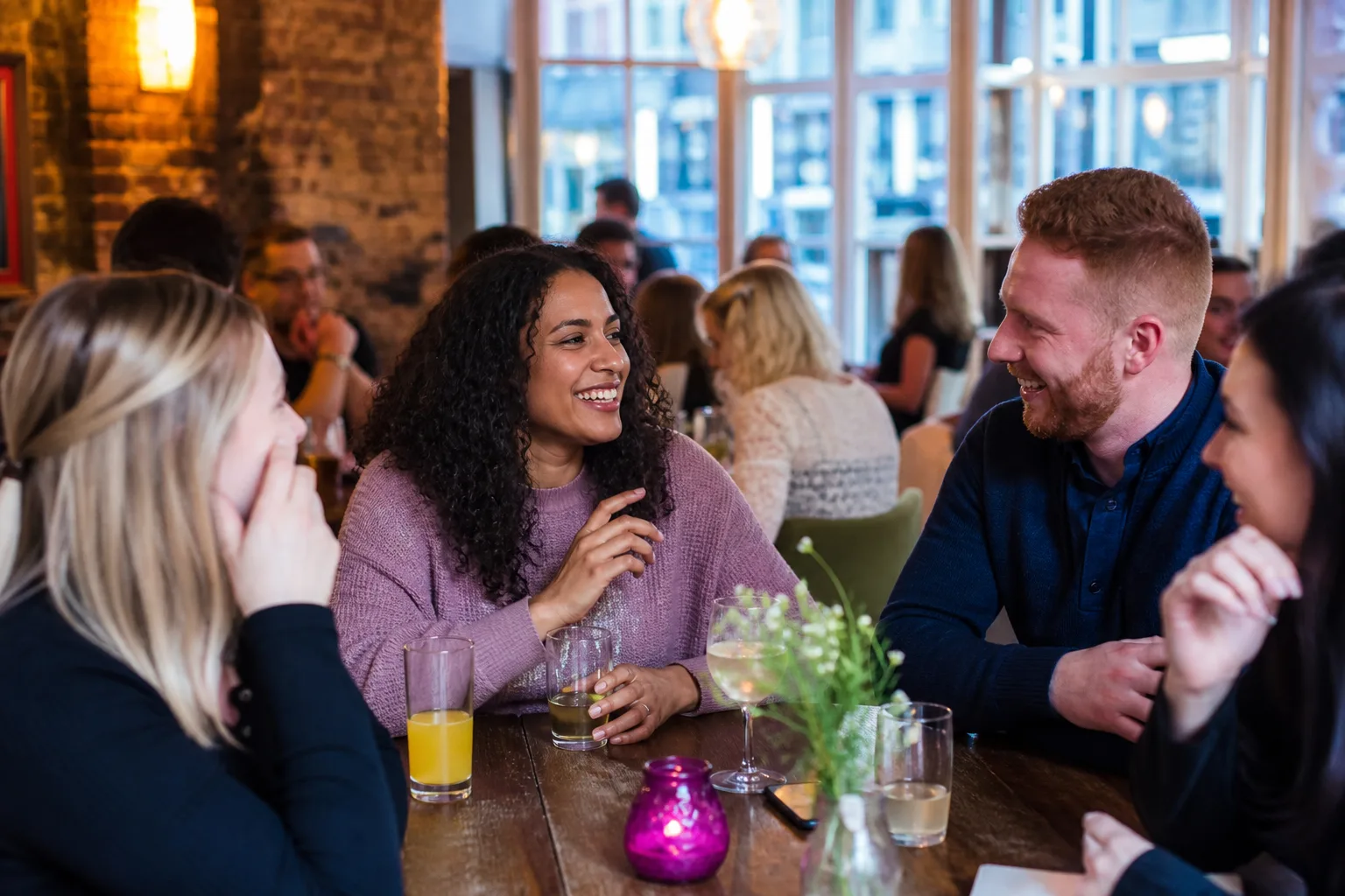 Single people chatting over drinks at an evening event in Leeds